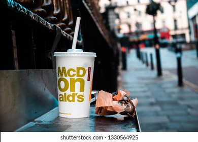 London / United Kingdom - 2.23.2019: McDonald's Paper Cup With A Plastic Straw, And A Paper Bag Left On The Street