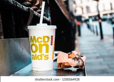 London / United Kingdom - 2.23.2019: McDonald's Paper Cup With A Plastic Straw, And A Paper Bag Left On The Street