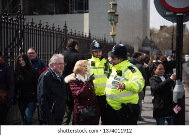 London, United Kingdom, April 13th 2019:- Two Police Officers Helping People Outside Westminster Parliament Of UK