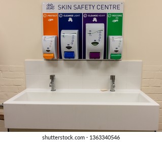 London / United Kingdom - April 8th 2019 : Deb Stoko Skin Safety Centre Cream Dispensers On A Wall In A Works Welfare Unit For Occupational Heath And Safety Above A Sink Front View