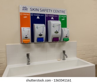 London / United Kingdom - April 8th 2019 : Deb Stoko Skin Safety Centre Cream Dispensers On A Wall In A Works Welfare Unit For Occupational Heath And Safety Above A Sink Side Angle View