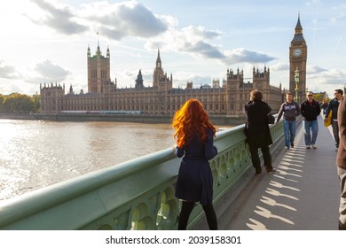 LONDON, UNITED KINGDOM - AUGUST 10, 2019: Red hair woman posing on Westminster Bridge near the Big Ben monument