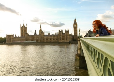 LONDON, UNITED KINGDOM - AUGUST 10, 2019: Red hair woman posing on Westminster Bridge near the Big Ben monument