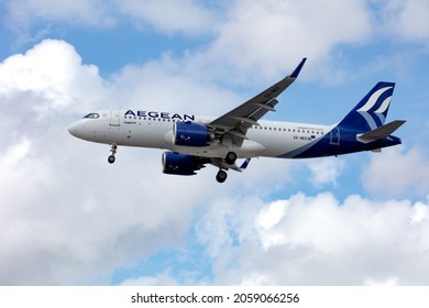 London, United Kingdom, August 2021 - Greek Airline, Aegean Air, Airbus A320 Neo flying low right to left displaying side view with its landing gear down across a cloudy sky