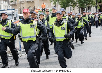 London, United Kingdom, August 3rd 2019:- Police run to form a line across a street in London to prevent Tommy Robinson supporters and anti facist demonstrators clashing