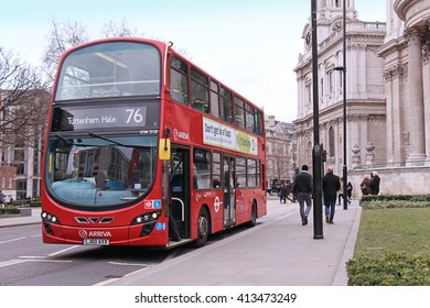 LONDON, UNITED KINGDOM - FEBRUARY 10: Famous TFL Red Bus On A Stop Near Millennium Bridge With People Walking By In London, UK - February 10, 2015; Traditional Red London Bus With Open Front Door.