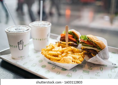 LONDON, UNITED KINGDOM - January 02, 2020: Shake Shack Hamburger in London city. Double cheeseburger with tomato lettuce and onion, Cheese Fries and Milkshake.