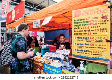 London, United Kingdom - July 23 2022: An Attendee At Hyper Japan Ordering Food At A Japanese Street Food Stall At Hyper Japan.