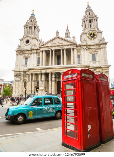 LONDON, UNITED KINGDOM - JUNE 11, 2013: Symbols of\
London in front of the St. Paul\'s Cathedral. Red phone booth and\
the London taxi near the Western portico of St. Paul\'s Cathedral.\
London, UK