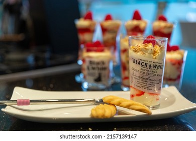 LONDON, UNITED KINGDOM - Mar 25, 2022: Whiskey Shots In Glasses With Scottish Shortbread And Strawberry Cream Desserts