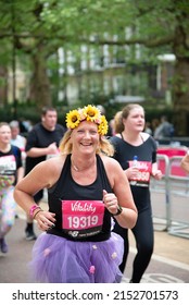 LONDON, UNITED KINGDOM - May 02, 2022: A Vertical Shot Of A Female Runner In A Purple Tutu With A Sunflower Headband During Vitality London 10000