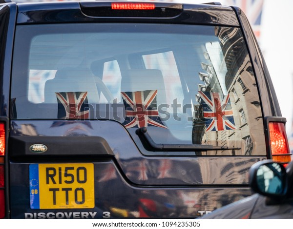 LONDON,\
UNITED KINGDOM - MAY 18, 2018: Reflection of Union Jack Flags on\
Regent Street a day before Royal Wedding between Prince Harry and\
Meghan Markle will be held at Windsor Castle\
