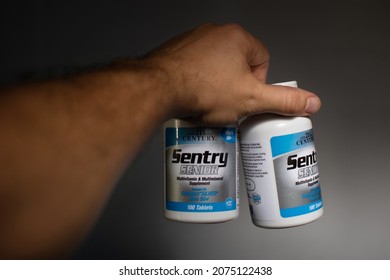 London, United Kingdom - November 13, 2021: Man Holding Two Bottles Of Sentry, White Unscented Multivitamins For 50 Plus Senior Men, Manufactured By 21st Century, In Tablets