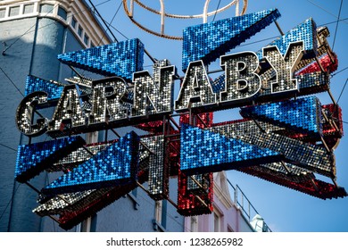 London, United Kingdom, November 17th 2018:- Sign Above Carnaby Street In The Soho Area Of London, Famous Since The 1960s For Its Independent Fashion Shops.