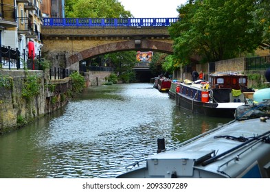 London, United Kingdom - Oct. 13 2013: Riverscape Of East London Canal, View Under Bridge Arc, River Disappear At The End, Billboard Ads On Top Of Canal.