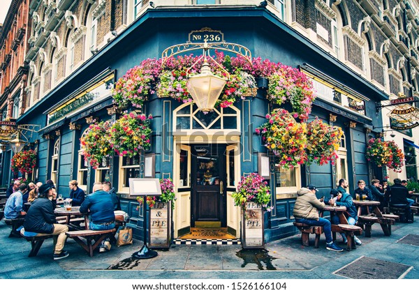 LONDON, UNITED KINGDOM - October 2019: Old\
traditional English Pub , Brewery, Pub entrance decorated with\
flowers in Central London, United\
Kingdom