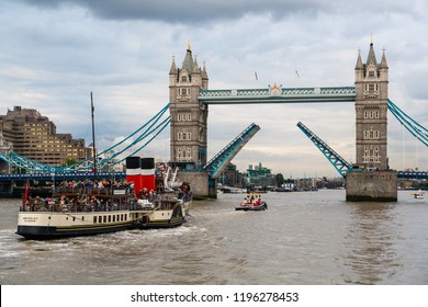 London, United Kingdom - October 4 13: A tug boat is towing tourist ship WAVERLEY under the open Tower Bridge