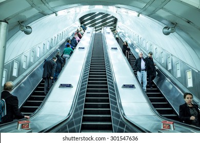 LONDON, UNITED KINGDOM - OCTOBER 8, 2014:  View of escalators and travelers inside London Underground