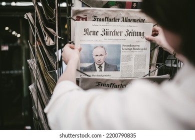 London, United Kingdom - Sep 9, 2022: Woman Taking From Press Kiosk Stand The Latest Neue Burcher Zeitung German Newspaper With Portrait Of Russian President Vladimir Putin And Headline Putin Sight