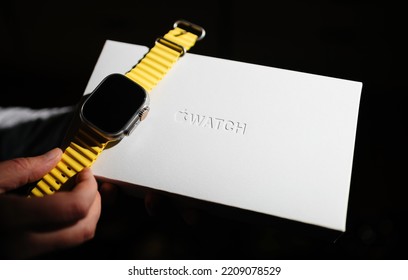 London, United Kingdom - Sept 28, 2022: Woman Holding New Apple Computers Apple Watch Ultra Next To Its Innovative Packaging - Black Background Embossed Engraved Logotype On Carton Box