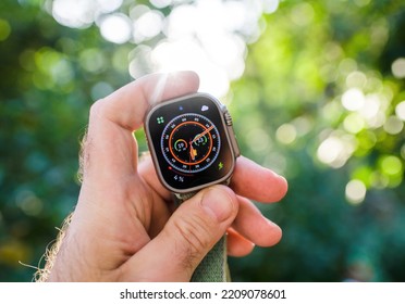 London, United Kingdom - Sept 28, 2022: Hand Holding New Apple Computers Apple Watch Ultra Wearable Green Nature Outdoor Adventure Background