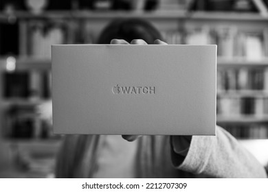 London, United Kingdom - Sept 28, 2022: Monochrome Black And White POV Woman Holding New White Cardboard Package Of New Apple Watch Ultra Titanium By Apple Computers