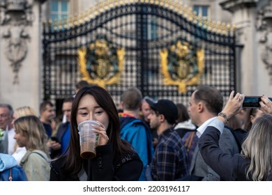 London, United Kingdom - September 9, 2022: The Crowd In Front Of The Buckingham Palace After The Death Of Queen Elizabeth II, A Woman Is Drinking Coffee