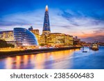 London, United Kingdom. Skyline view of the famous New London, City Hall and Shard, golden sunset hour. View includes Thames River, skyscrapers, office buildings and beautiful sky.