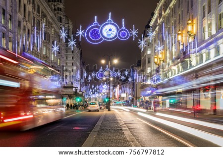 London in winter time: decorated highstreet with christmas lights and passing by red bus