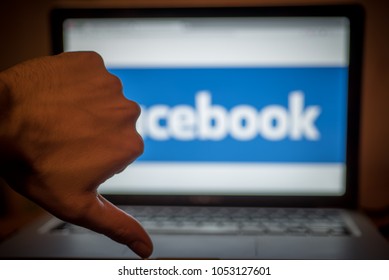 London,England, 03/22/2018 - Mans Hand Thumbs Down Dislike In Front Of Facebook Logo On A Laptop Screen 