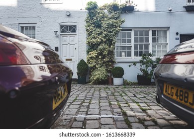 London/UK - 22/07/19: The Facade Of A House Viewed Between Bumpers Of Two Porche Cars In Upbrook Mews In Bayswater, An Affluent Area Within The City Of Westminster