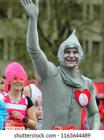 London/UK 4/22/12 Virgin London Marathon 2012. Passing By Buckingham Palace A Male Runner In A Tin Man Costume Approaches The Nearby Finish Line