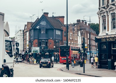 London/UK - July 17, 2019: People Walking Past The Camden Eye Pub On The Cross Of The Kentish Town Road And Camden Road In Camden Town. Pubs Are A Big Part Of British Culture