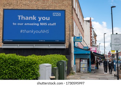 London.UK-05.13.2020: A Large Digital Display On The Side Of A Building With A Message Thanking NHS Staff. A Street Scene With Pedestrians And Shops.