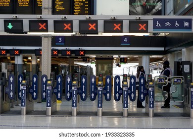 LONDON,UK-26.2.2021:  Please Keep Your Distance Sign And People Icon On Automatic Gates When Touching To Pay To Enter To And Exit Train Station With Timetable And Platform In Behind, London UK