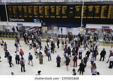 London/UK-28 August 2019. Commuters at the main concourse of London Waterloo train station walking past and checking the large departures board, London, UK - Shutterstock ID 1593501868