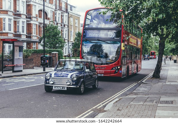 London/UK-30/7/18: the purple mini cooper and the\
Routemaster on Abbey Road in the City of Westminster. The red\
double-decker bus and Mini Cooper both has become a national symbol\
of England