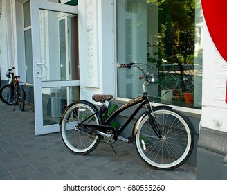 A Lone Bicycle With Tiger-colored Seating Is At The Store Window