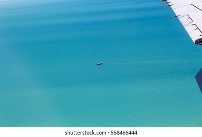 Lone Boat In The  Aqua Indian Ocean , Broome, North Western Australia, Seen From The Air As The Plane Descends For Landing On A Hot Cloudy Afternoon In The Summer Wet Season Is Calm And Serene.