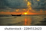 Lone boat standing in the shore at the time of evening and the sun on the other side is going down.The queen of sun set in Bangladesh. Kuakata sea beach,Bangladesh.