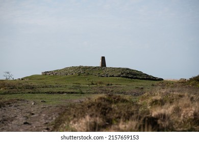 A Lone Building On Top Of The Hill In The Field