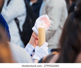 Lone candle guiding devotion through Granada’s solemn holy week procession (Granada, Spain: 01-apr-2026)