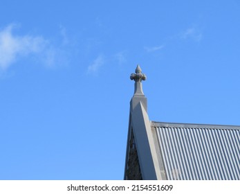 A Lone Church Spire Pierces The Soft Blue Sky, Pointing To Heaven.