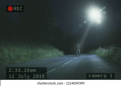 A Lone Figure Standing In The Road At Night While Looking At A UFO And Beam Of Light In The Sky. With A CCTV Edit.