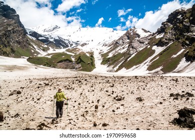 A lone hiker looks at the view of the Himalayas on the Beas Kund trek in northern India
