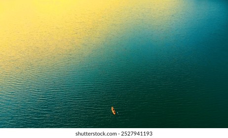 Lone kayak on calm open water. A lone kayaker paddles across a vast expanse of calm water, bathed in soft, golden light. - Powered by Shutterstock