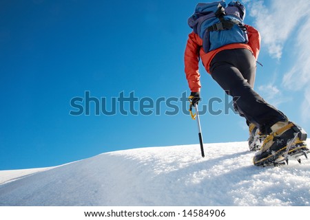 Lone male mountain climber climbing a snowy ridge; Mont Blanc, Europe.