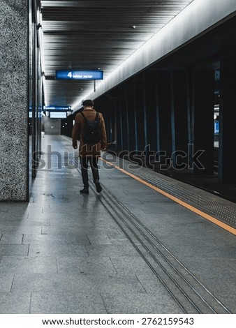 lone man with a backpack on the train station platform