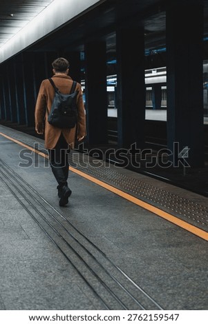 lone man with a backpack on the train station platform