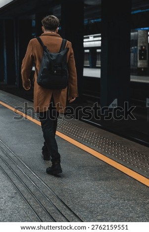 lone man with a backpack on the train station platform